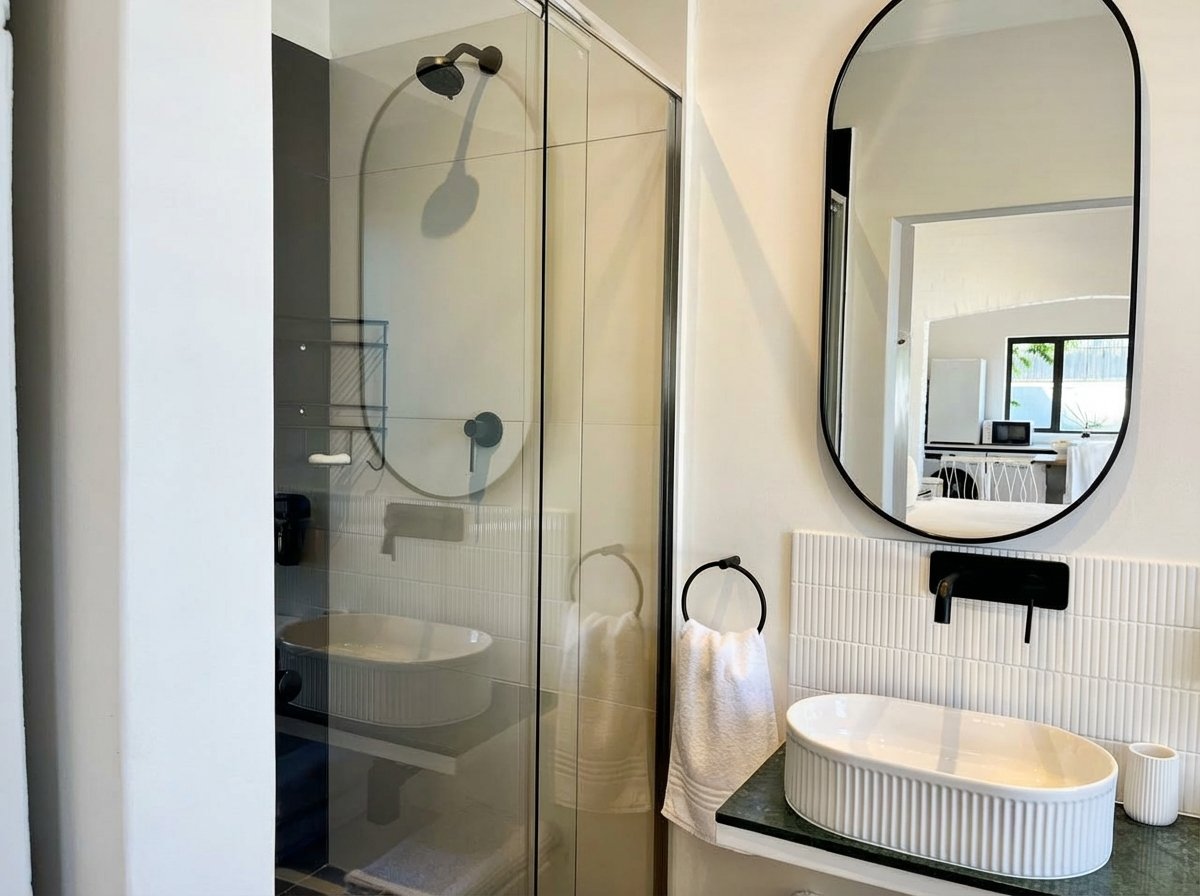 Bathroom with generous shower, arched mirror and modern vessel sink