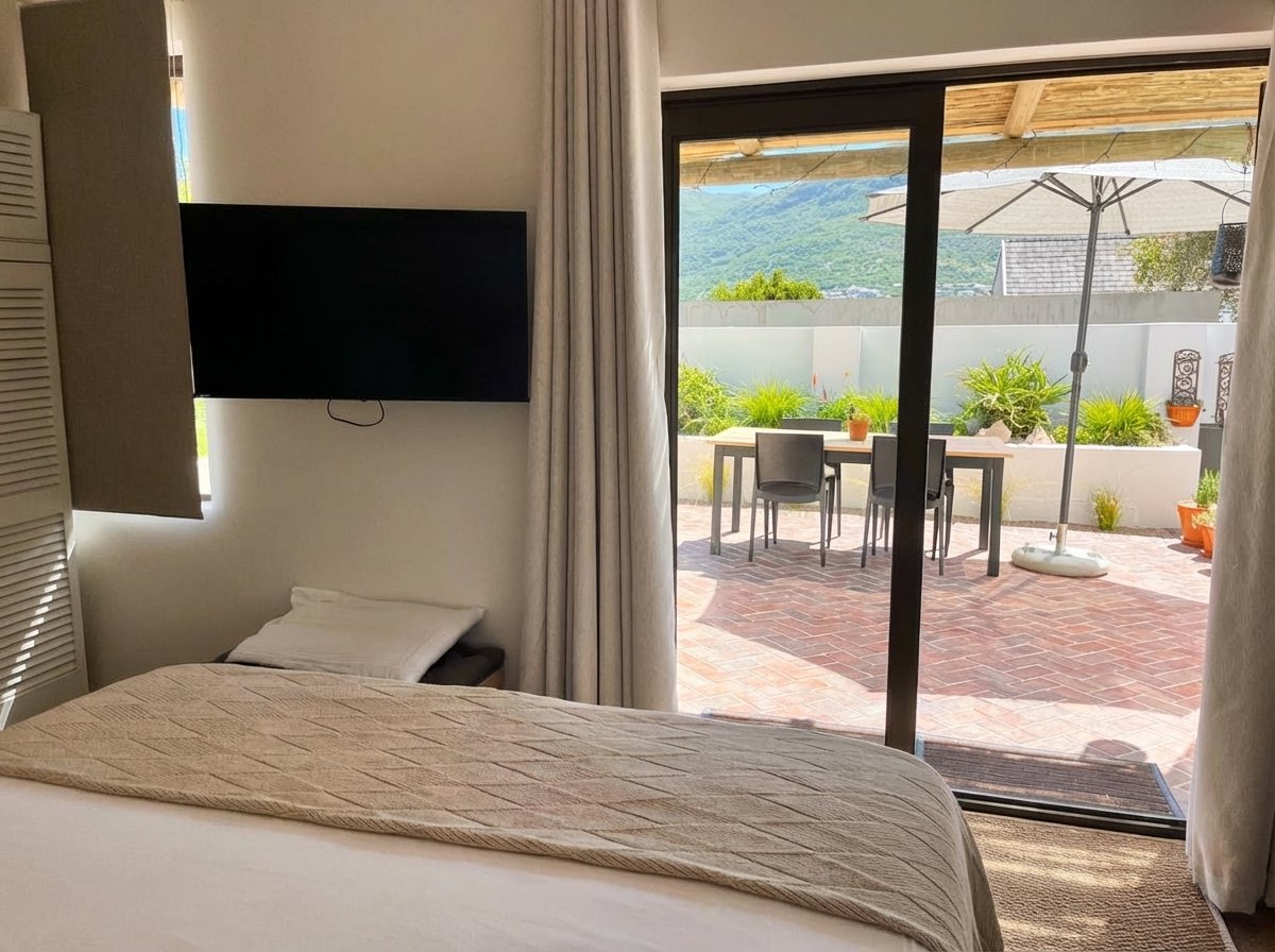 Bedroom view with wall-mounted flat screen TV and patio mountain views